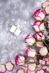 Bouquet of roses with perfume on a gray background with copy space
