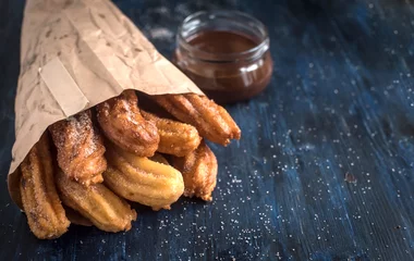 Gordijnen Traditionele Mexicaanse dessertchurros geserveerd op tafel, selectieve focus en lege ruimte © ltummy