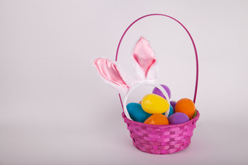 Easter egg basket with bunny ears and bright plastic Easter eggs