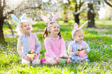 Easter egg hunt. Kids with bunny ears and basket.