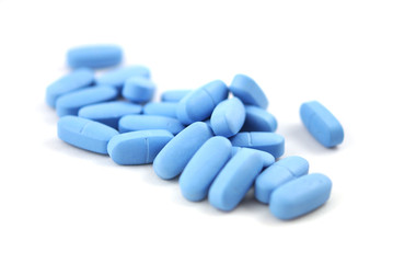 Big blue oval tablets closeup on white background