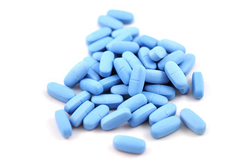 Big blue oval tablets closeup on white background