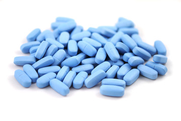 Big blue oval tablets closeup on white background