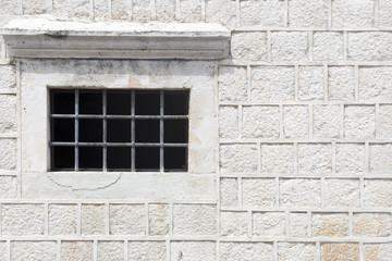 grey stone wall with grating window