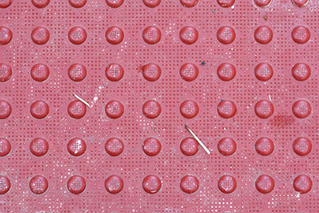 Red diamond plate closeup abstract texture background with litter and debris. 