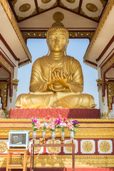 Front view of a golden statue of Buddha in lotus position on the Sagaing Hill in Mandalay, Myanmar (Burma) on a sunny day.