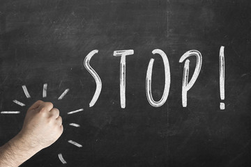 fist and inscription stop on chalkboard.
