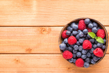 Juicy and fresh blueberries with green mint on rustic blue table.