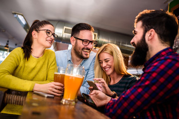 Friends in pub having fun drinking, laughing