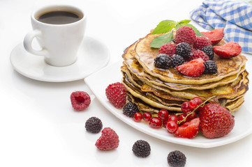 Delicious pancakes with berries and maple syrup on a white background