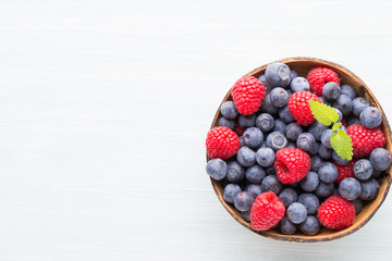 Juicy and fresh blueberries with green mint on rustic blue table.