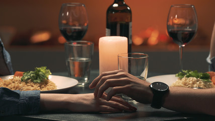 Man touches woman's hand during a romantic date. Close-up