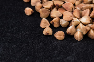buckwheat groats on black background. Pile of buckwheat groats Close up