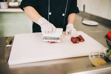 man prepares raw beef steak before cooking - 193348038