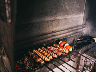 shish kebabs, vegetables, tomatoes, sweet peppers, champignons are cooked on the grill - 193348064