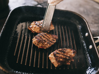 three juicy beef steaks are cooked on the grill - 193348065