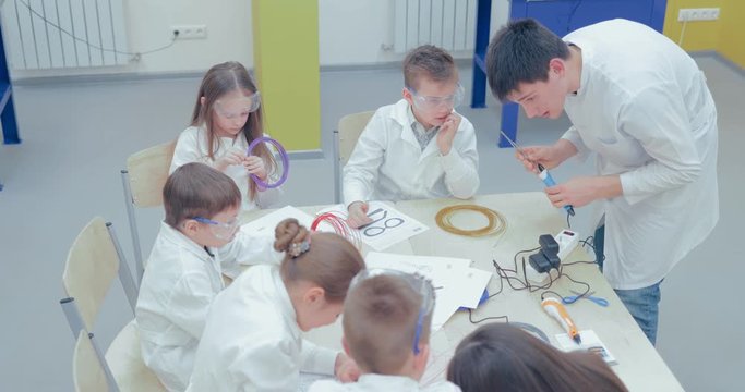 Teacher prepares 3d pens for drawing in the laboratory