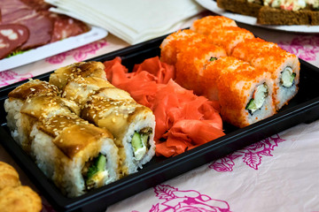 Small set of sushi rolls on the black plate