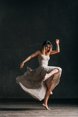 Young beautiful female dancer is posing in the studio