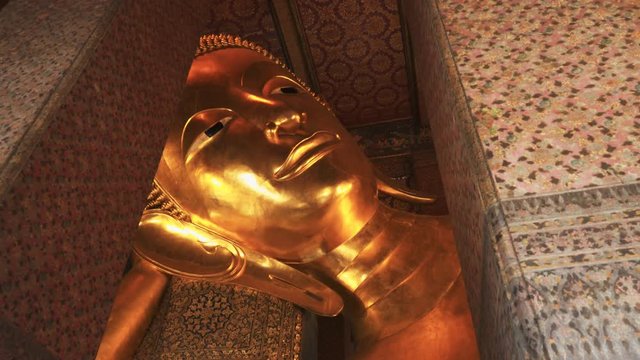 hand held shot of the reclining buddha at wat pho temple in bangkok, thailand