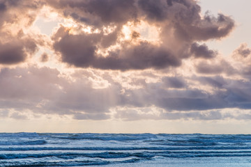 sunset in the cloudy sky at sea