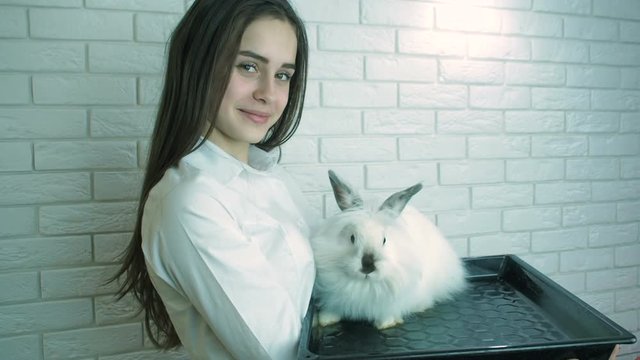 Girl with a white bunny. Rabbit on a baking sheet. Easter bunny.