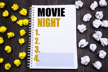 Conceptual hand writing text caption showing Movie Night. Business concept for Wathing Movies  Written on notepad note notebook book wooden background with sticky folded yellow and white