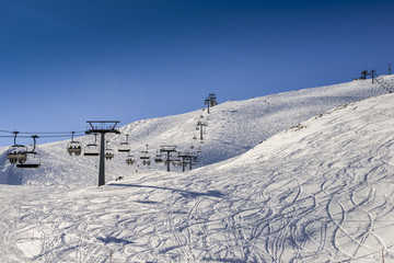 Chairlift at Italian ski area on snow covered Alps during the winter