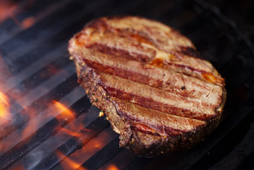 ribeye rib eye roast beef steak on bbq barbecue grill with flame