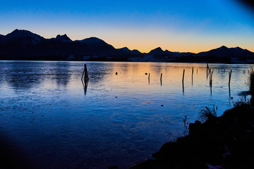 Zugefrorener See Sonnenuntergang  mit spiegelnder Eisschicht ang 