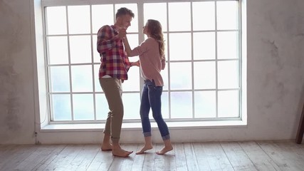Young couple at home together saint valentine's day concept near window dancing