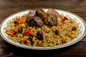 Uzbek national pilaf dish on a dark wooden background