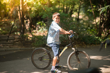 Fototapeta premium Little boy riding a bike in the park