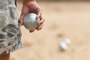 Hand of female boule holding boule or petanque ball on match