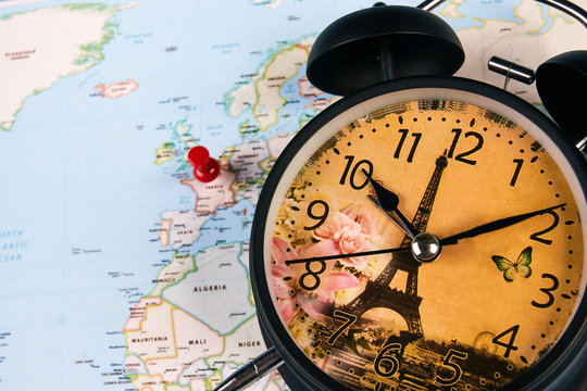 Planing for travel to France Paris with worldmap globe and alarm clock. Travel time in Europe concept. European holidays. traveling background with copy space.