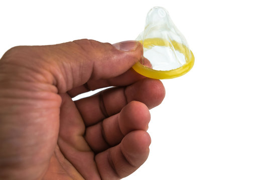 Close-up of a condom in his hand. Contraceptive protection against pregnancy, AIDS.