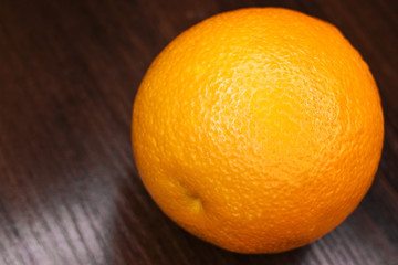 Large orange on a wooden background.
