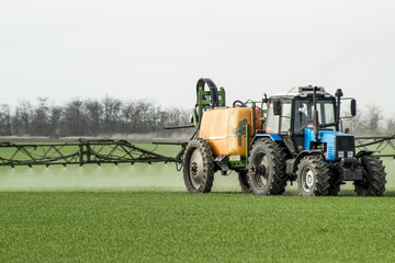 Tractor with a spray device for finely dispersed fertilizer.