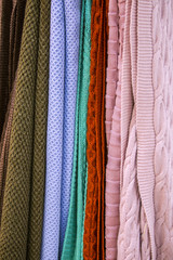 Knitted multi-colored plaids, blankets, knitted fabric textures in the store