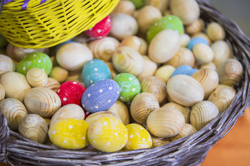 Basket with wooden workpieces of Easter eggs, eggs colored in different colors