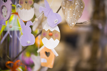 Colorful handmade wooden Easter elements: eggs, rabbits, chick. Easter bright, abstract, blurred background. Easter tree