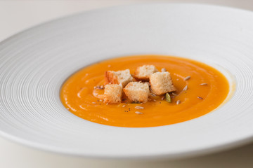 Pumpkin cream soup in white plate