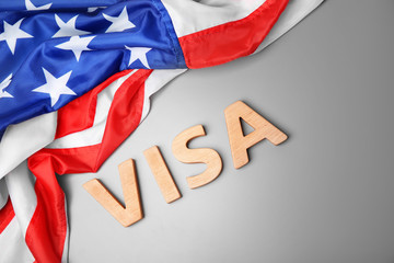 Word VISA and American flag on grey background