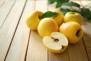 Naklejka na ściany i meble Ripe yellow apples on wooden background