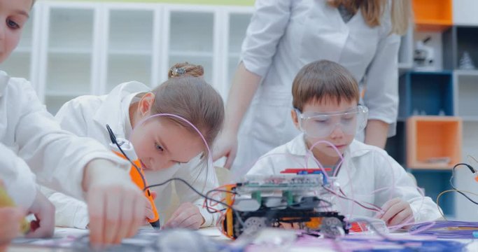 Little girl and boy paints using 3D pen, melted plastic is extruded out of the pen