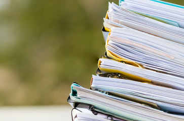 Stack of papers documents in archives files with clip papers on table at offices,  Busy offices and Pile of data unfinished folders on office desk indoor,  Business concept