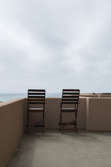 Table and two chairs on a balcony by the sea Apartment