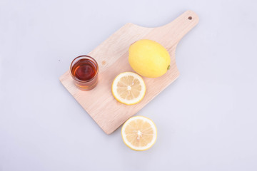 Lemon on a wooden cutting board with honey