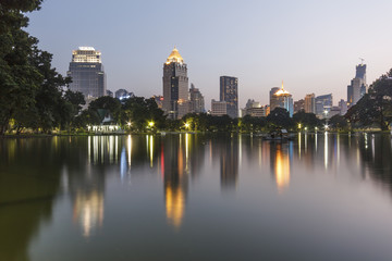 Business district cityscape from a park with twilight time from lumpini park, Bangkok Thailand