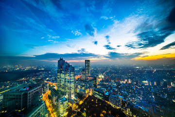 Asia Business concept for real estate and corporate construction - panoramic modern city skyline aerial night view of Shinjuku and Tokyo Metropolitan Expressway under twilight sky in Tokyo, Japan
